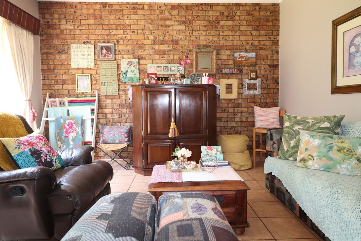 A cozy living room featuring a prominent exposed brick feature wall and durable ceramic tile flooring, offering a warm and rustic aesthetic.