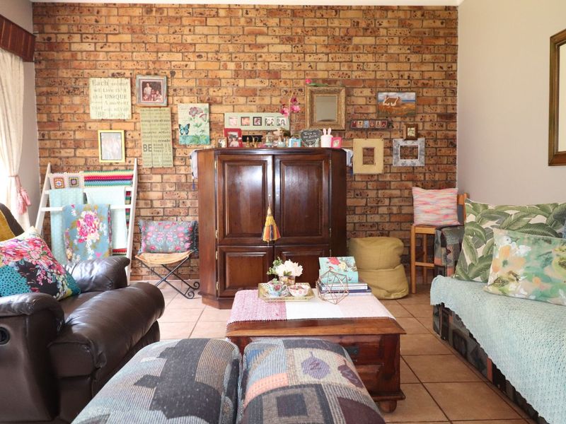 A cozy living room featuring a prominent exposed brick feature wall and durable ceramic tile flooring, offering a warm and rustic aesthetic.