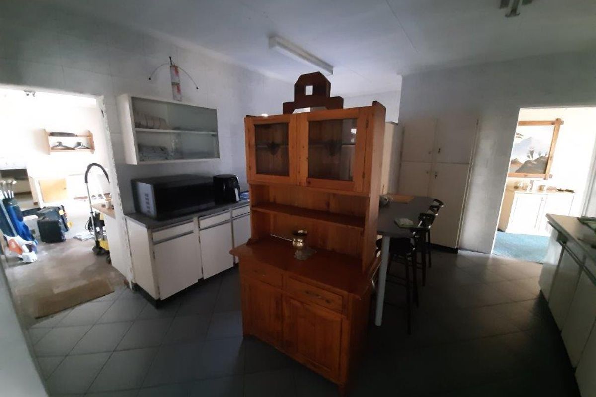 A dated kitchen area featuring built-in cabinetry and tiled flooring, offering significant potential for modernization and renovation.
