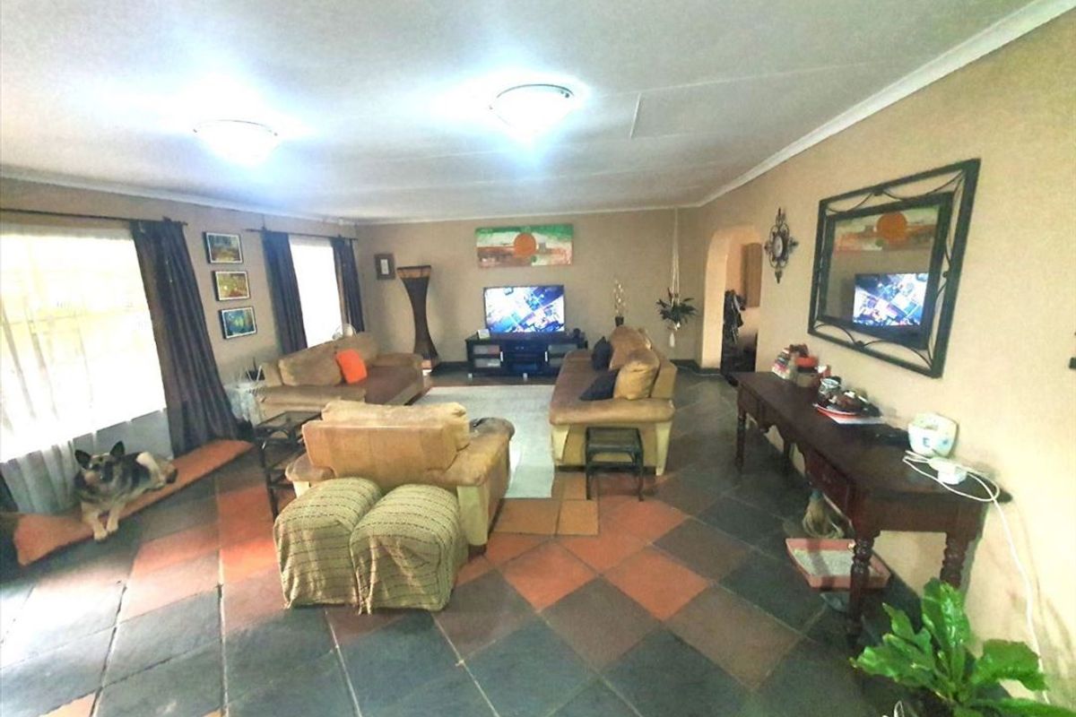 Spacious living room featuring traditional slate tile flooring and a neutral color palette, offering a comfortable and functional family living space.