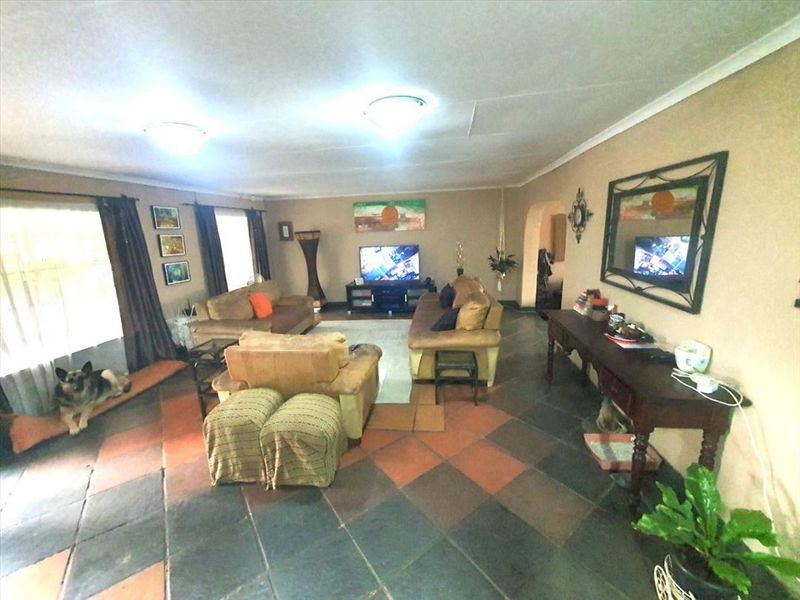 Spacious living room featuring traditional slate tile flooring and a neutral color palette, offering a comfortable and functional family living space.