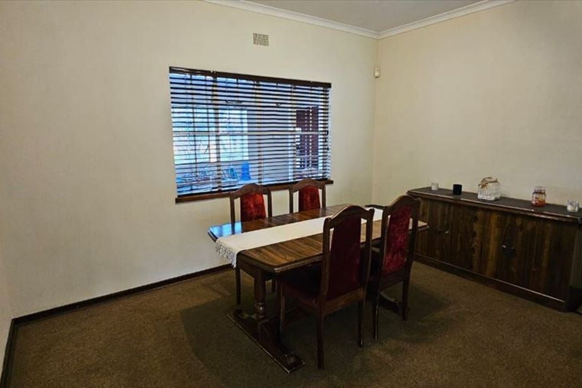 A functional dining room featuring carpet flooring, coving, and venetian blinds, providing a neutral space ready for modern updates.