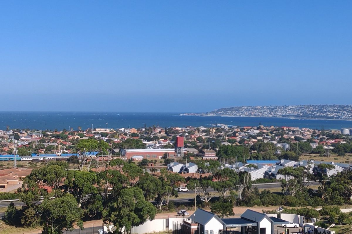 A panoramic elevated view overlooking the coastal town, surrounding landscape, and the ocean horizon.