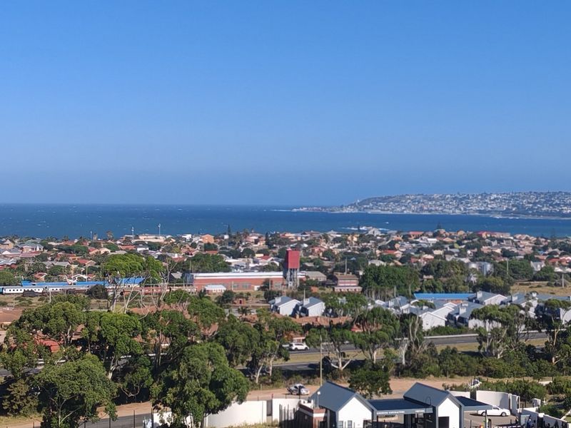 A panoramic elevated view overlooking the coastal town, surrounding landscape, and the ocean horizon.