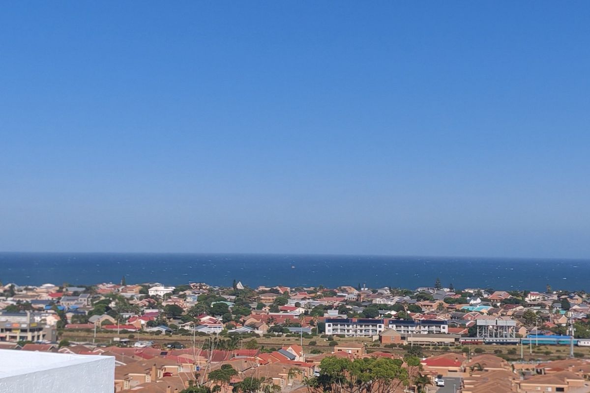 An elevated panoramic view overlooking the coastal residential neighborhood and the ocean horizon.