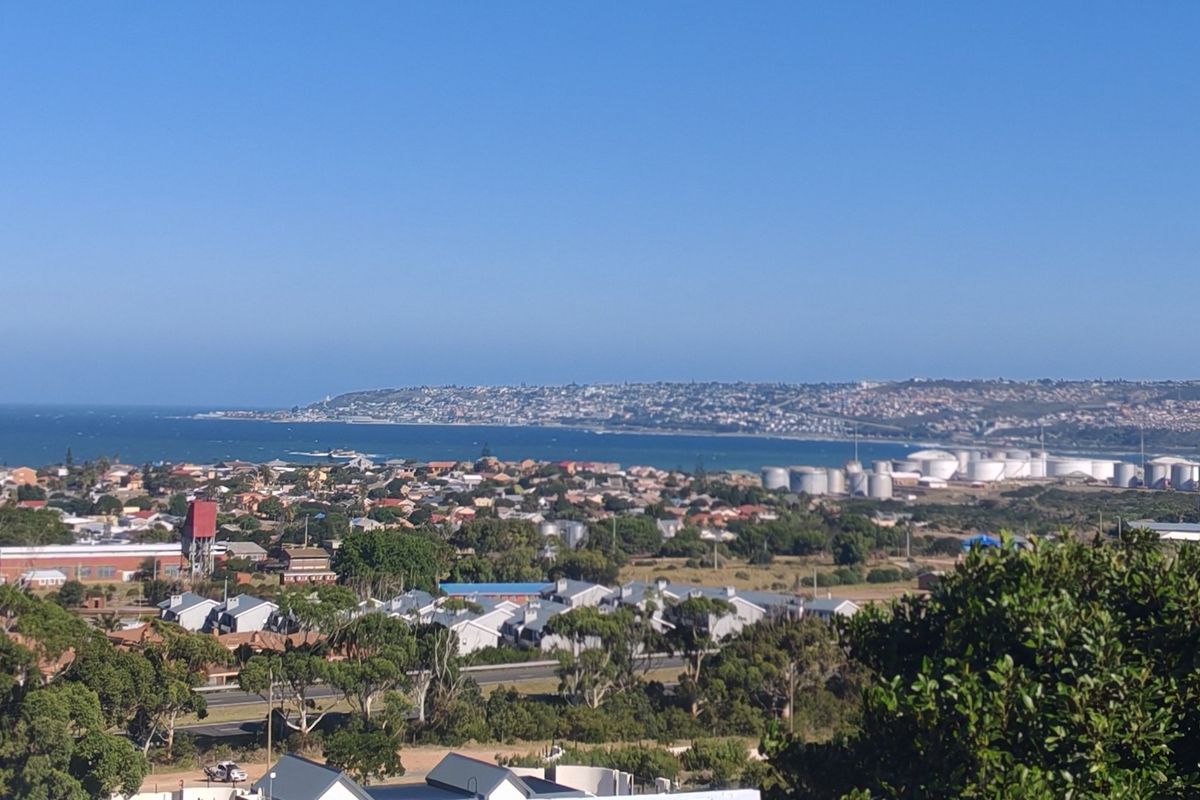A panoramic elevated view overlooking the coastal town, surrounding residential areas, and the ocean horizon.