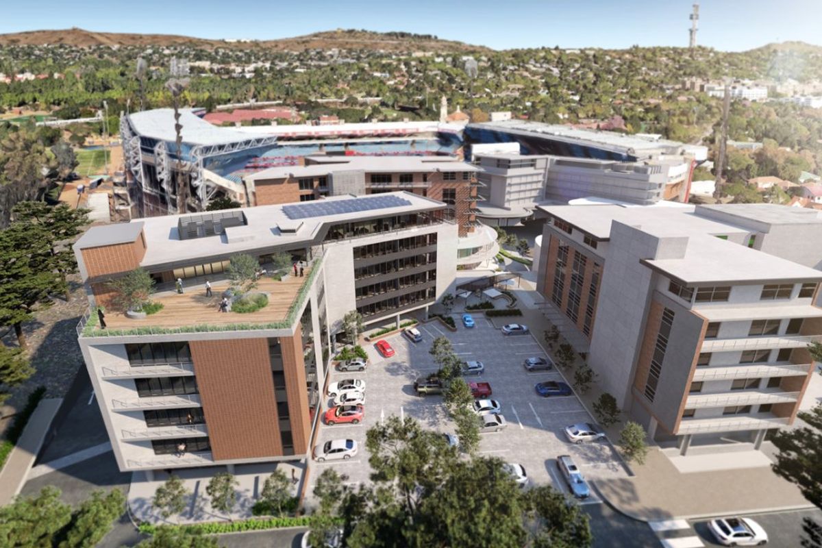 Aerial view of a modern commercial office complex featuring multi-story buildings, rooftop terraces, and an integrated parking area.