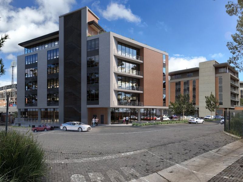 Modern multi-story commercial office building featuring a contemporary glass and brick facade with integrated balconies and paved exterior access.