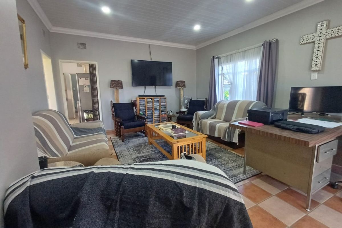 A spacious living room featuring tiled flooring, recessed downlighting, and a coved ceiling, providing a functional and comfortable family living area.