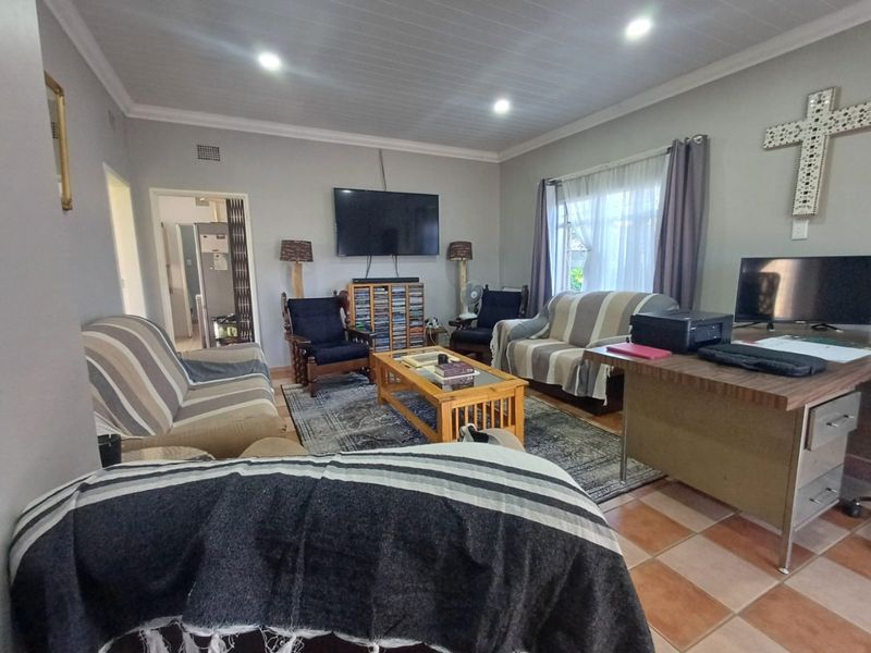 A spacious living room featuring tiled flooring, recessed downlighting, and a coved ceiling, providing a functional and comfortable family living area.