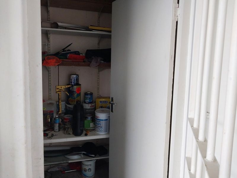 A small utility storage cupboard featuring adjustable wall-mounted shelving, suitable for general household storage or pantry use.