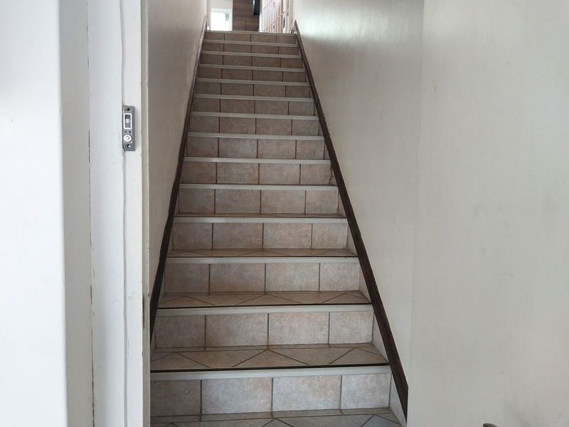 A functional tiled staircase leading to the upper level, featuring standard stair nosing and plain wall finishes.