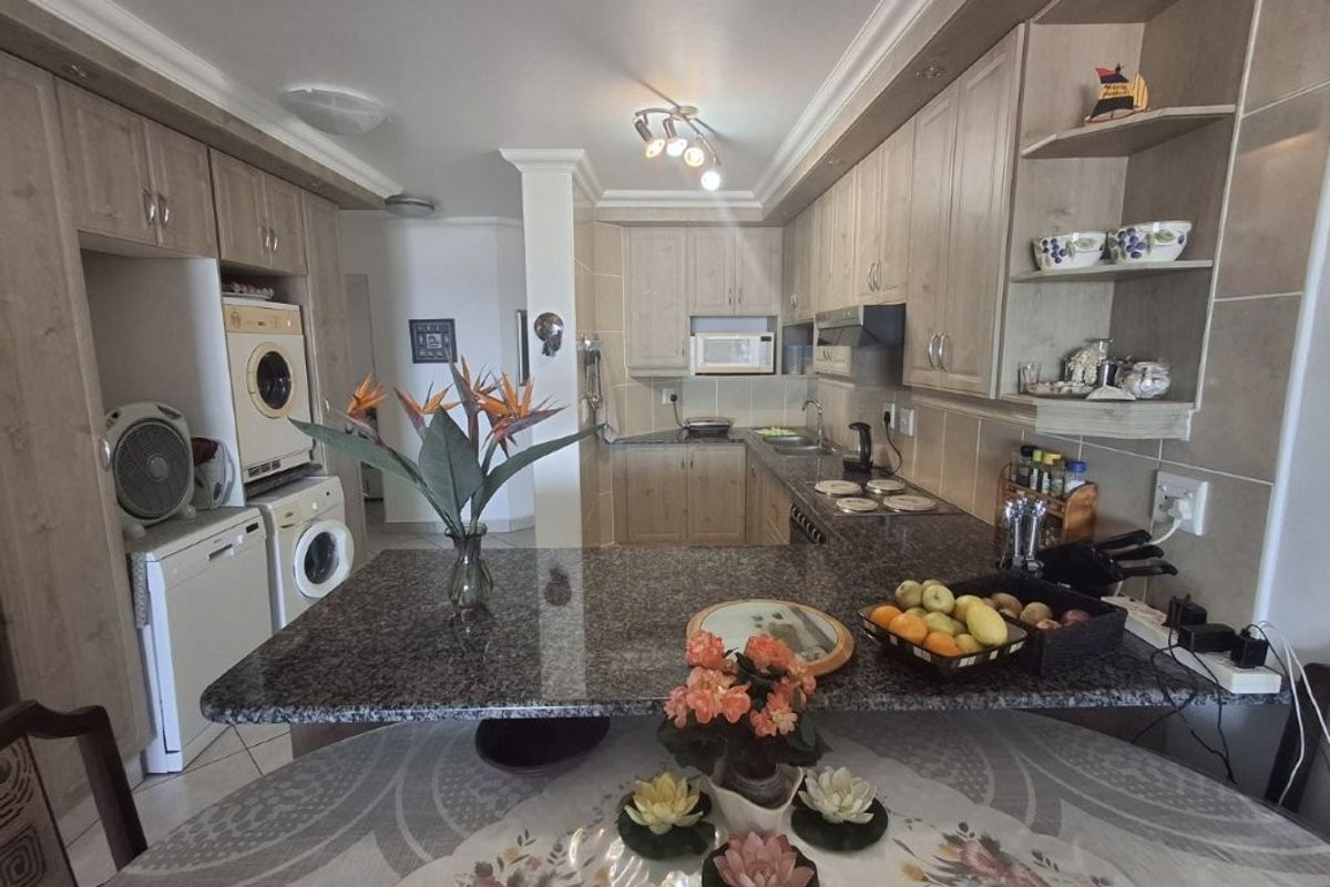 Functional kitchen featuring granite countertops, ample built-in cabinetry, integrated appliances, and a breakfast bar area, offering a practical layout for daily use.