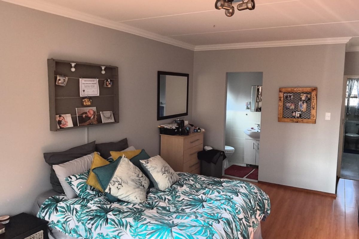A bedroom featuring laminate flooring and an en-suite bathroom, providing a functional and comfortable living space.