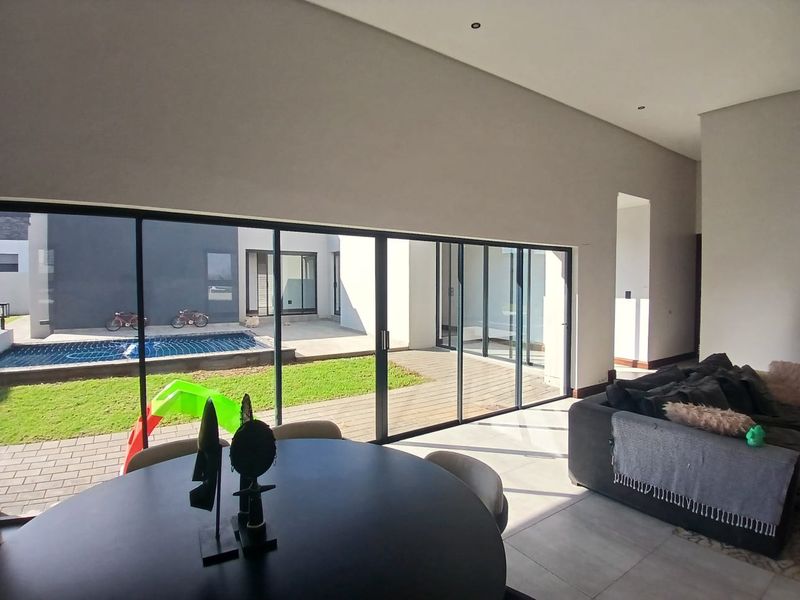Spacious open-plan living area featuring large sliding glass doors that provide seamless indoor-outdoor flow to the patio and pool area.