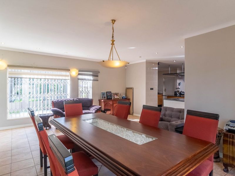 Spacious open-plan dining and living area featuring tiled floors, recessed lighting, and a seamless flow into the adjacent kitchen space.