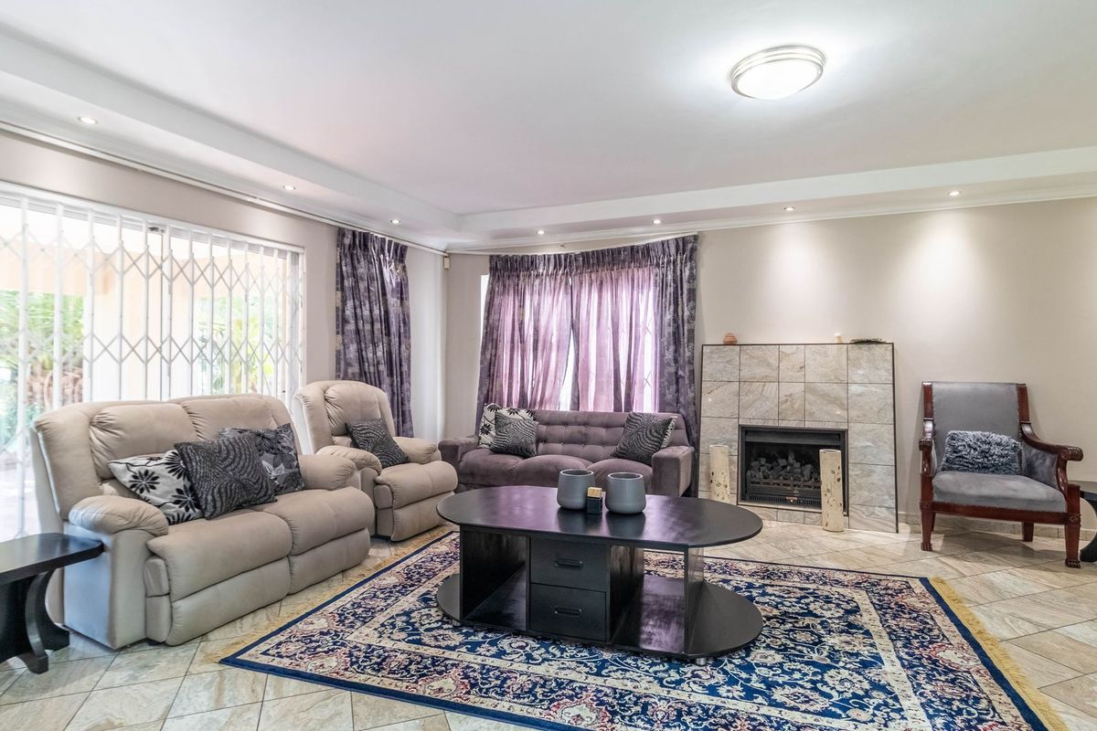 Spacious living room featuring tiled flooring, a built-in fireplace with tiled surround, and sliding door access to the outdoor area.