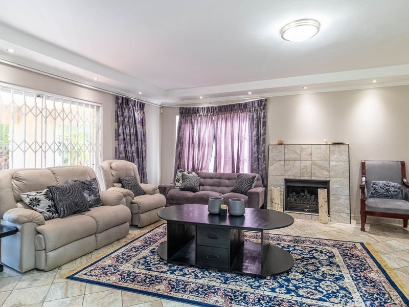 Spacious living room featuring tiled flooring, a built-in fireplace with tiled surround, and sliding door access to the outdoor area.
