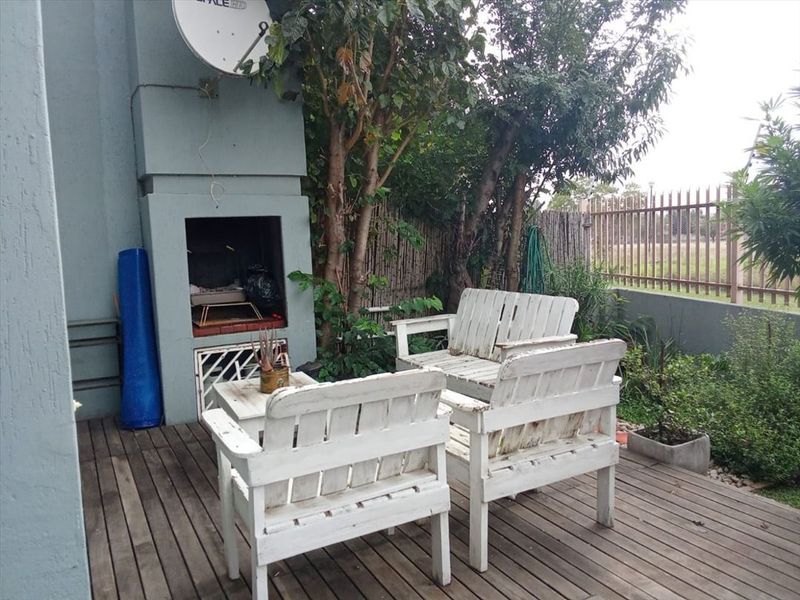 Outdoor patio area featuring timber decking and a built-in braai, providing a functional space for outdoor entertainment.