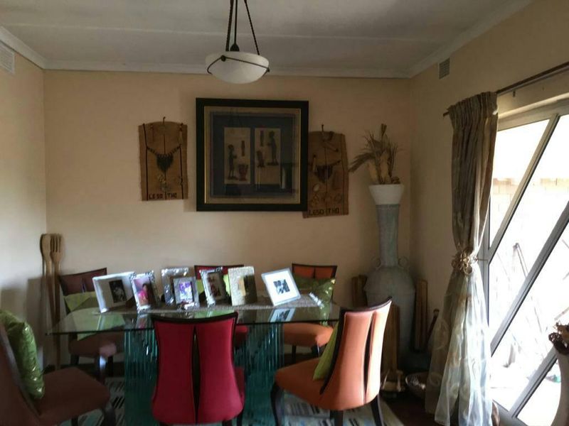 A dining area featuring a pendant light fixture and access to an outdoor space through a sliding glass door.