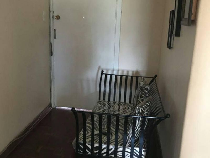 A compact apartment entryway featuring parquet flooring and a secure entrance door.