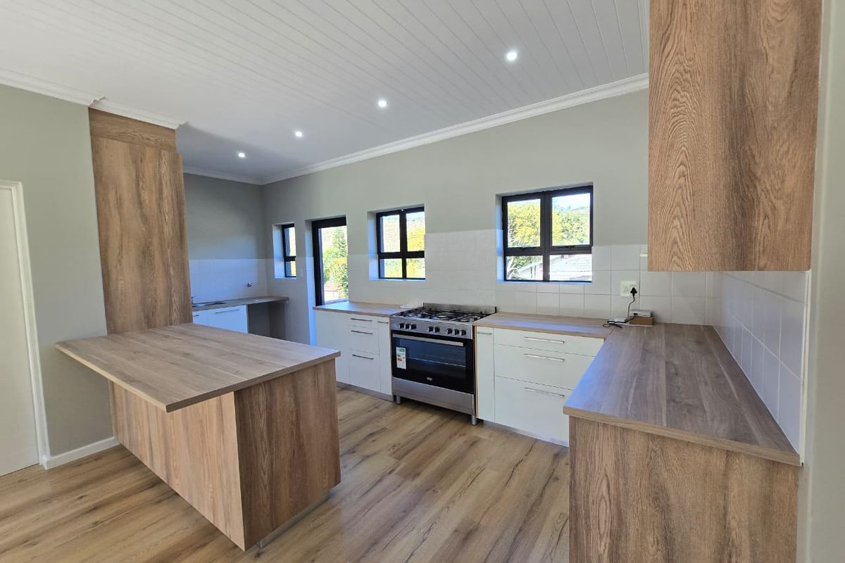 Modern kitchen featuring wood-look cabinetry, laminate countertops, gas stove, and recessed lighting in a clean, open-plan layout.
