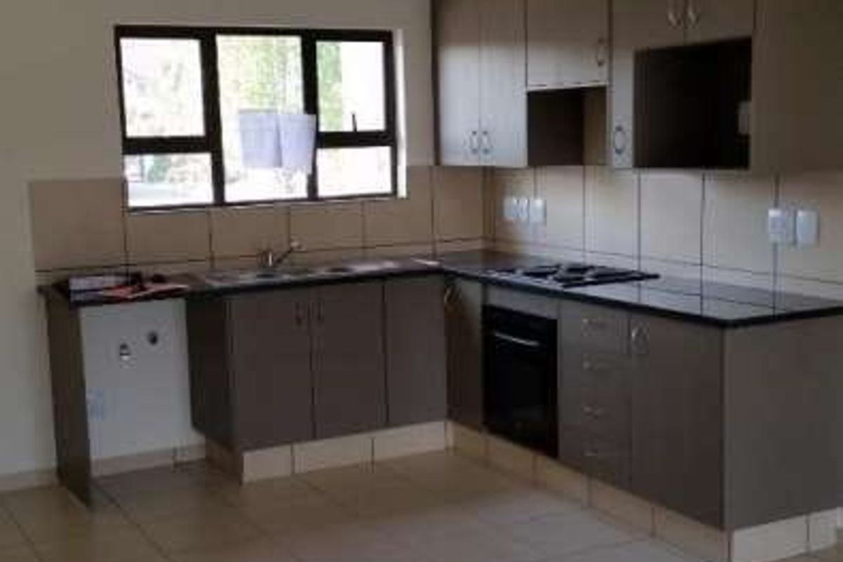 A functional kitchen featuring built-in cabinetry, granite countertops, a built-in oven, and hob, finished with tiled flooring and a tiled backsplash.