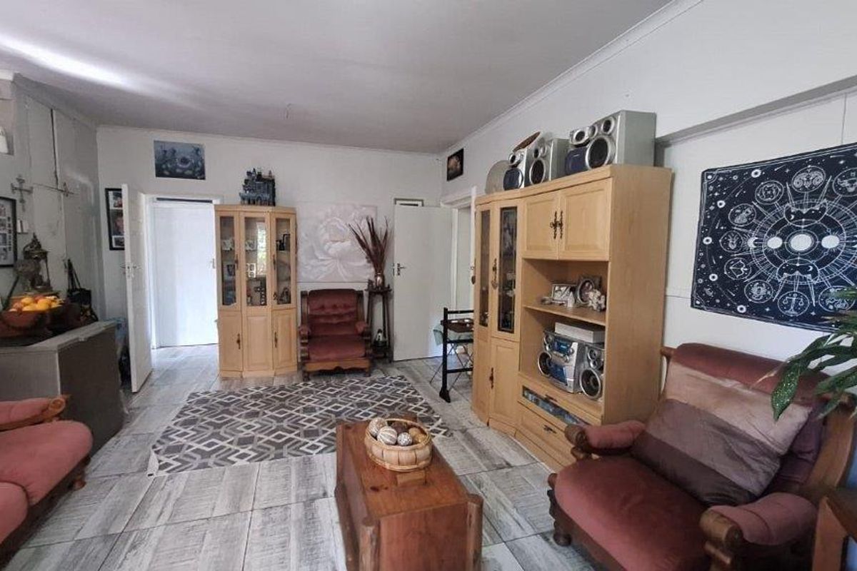 A spacious living room featuring light-toned tiled flooring and neutral wall finishes, offering a versatile layout for comfortable family living.