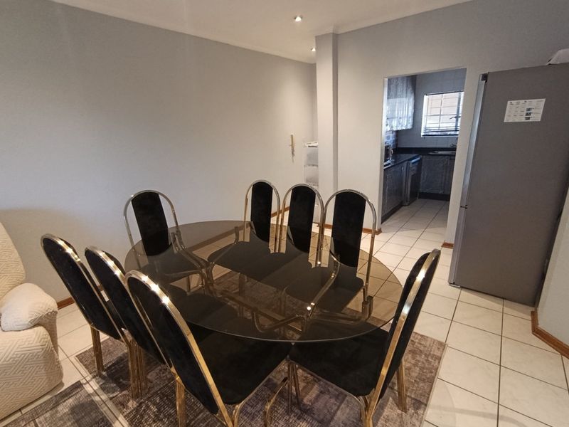 Open plan dining area featuring tiled flooring and recessed lighting, with a direct view into the adjacent kitchen space.