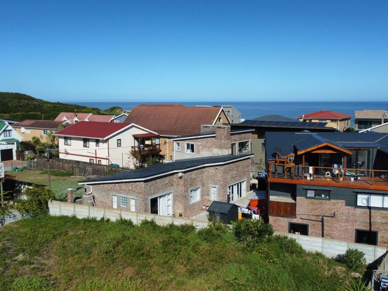 Aerial view of a residential neighborhood featuring brick homes, pitched roofs, and coastal proximity.