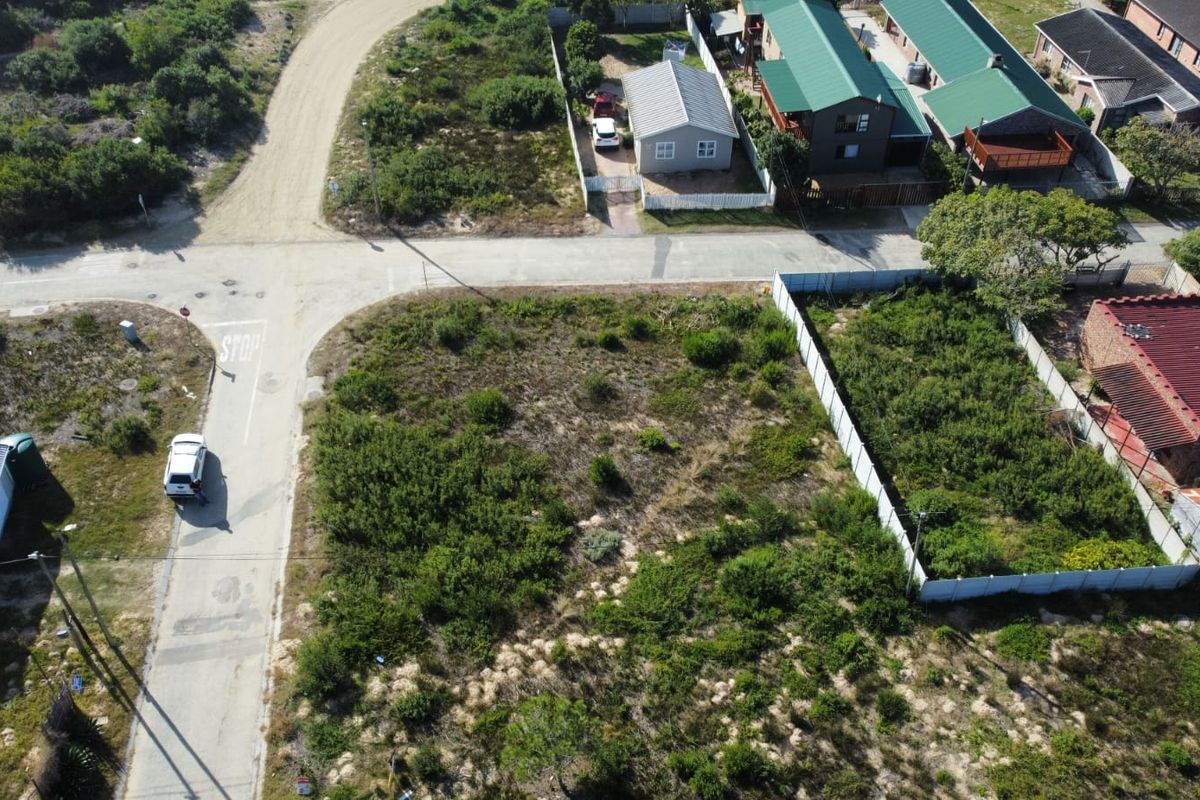 Aerial view of a vacant residential plot featuring natural vegetation and perimeter fencing, situated in a developed neighborhood.
