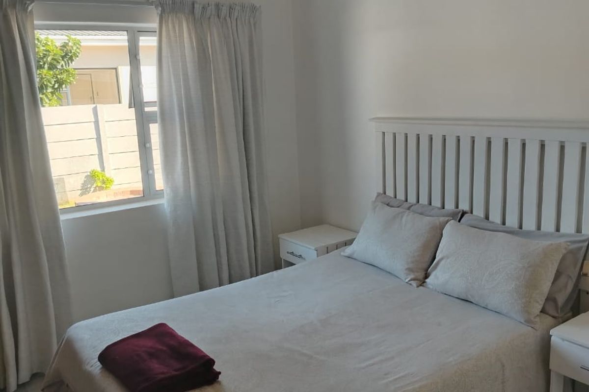 A clean and functional bedroom featuring tiled flooring and a window, providing a neutral space ready for personalization.