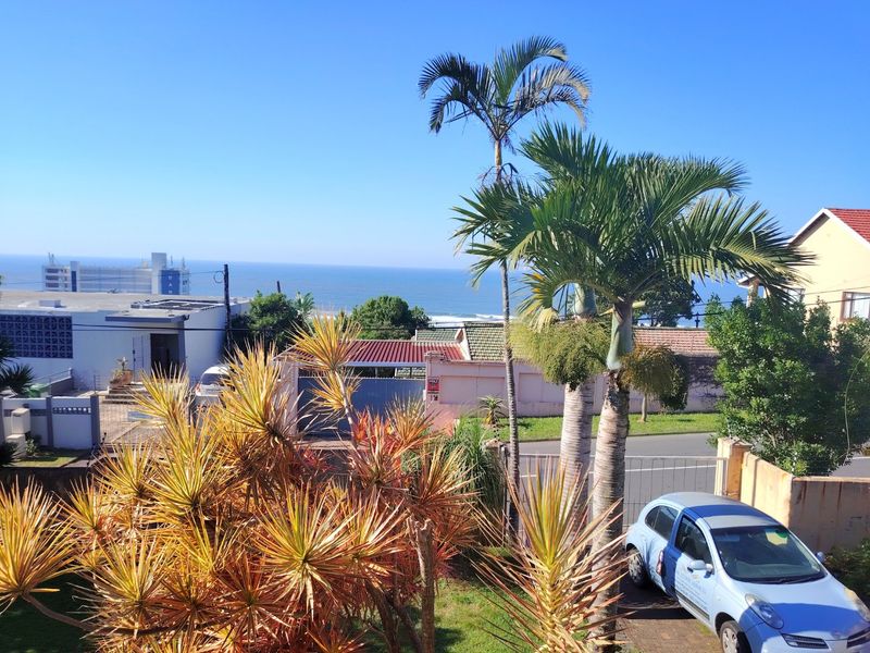 An elevated view overlooking the neighbourhood with a clear outlook towards the ocean and coastline.