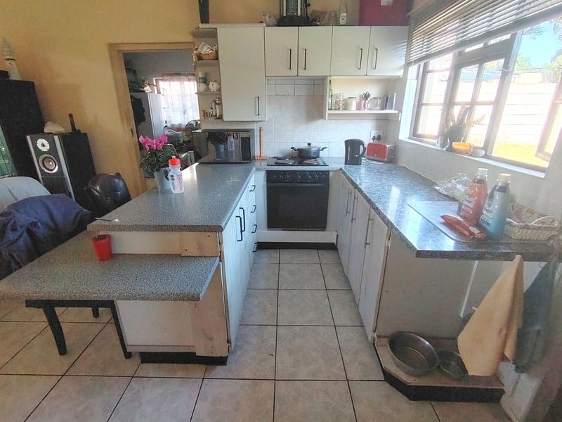 A functional kitchen featuring built-in cabinetry, laminate countertops, and a built-in oven, offering potential for cosmetic updates to modernize the space.