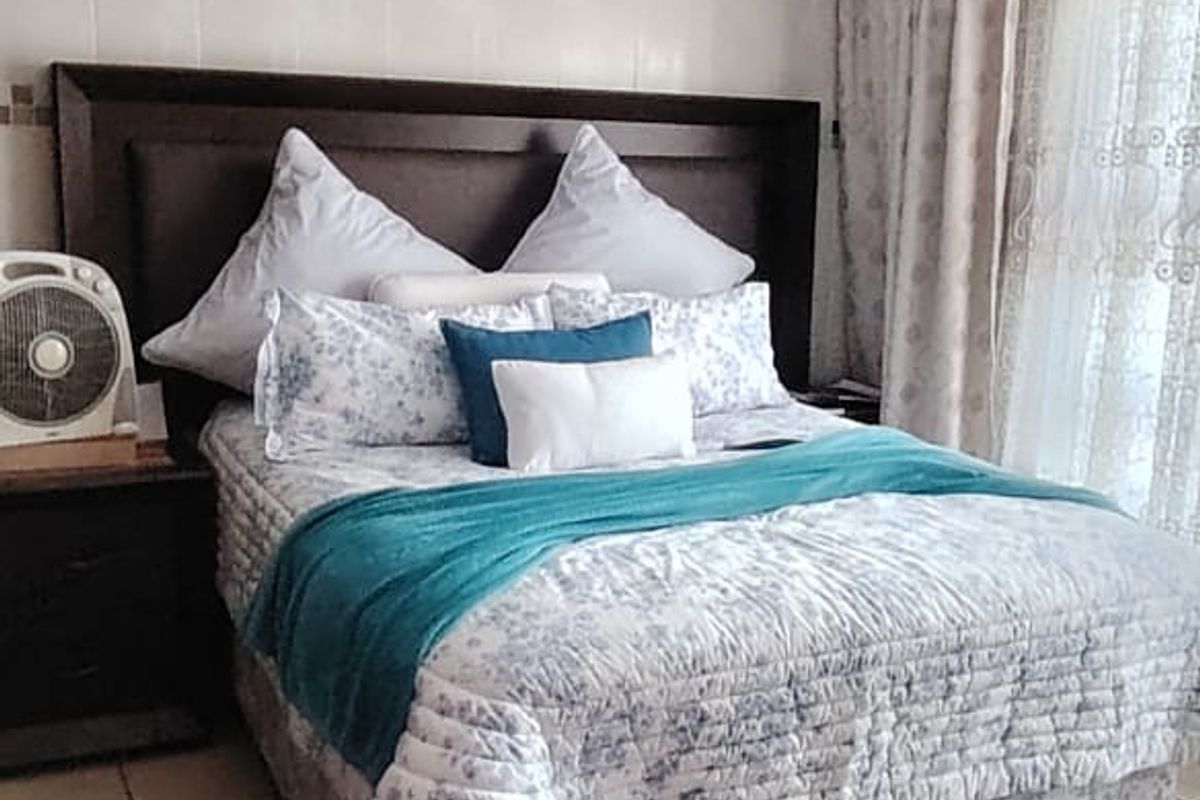 A bedroom featuring tiled flooring and a beadboard ceiling, providing a functional and neutral space.