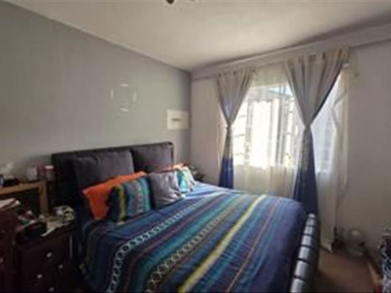 A standard bedroom featuring a window with curtain rails and neutral wall finishes.