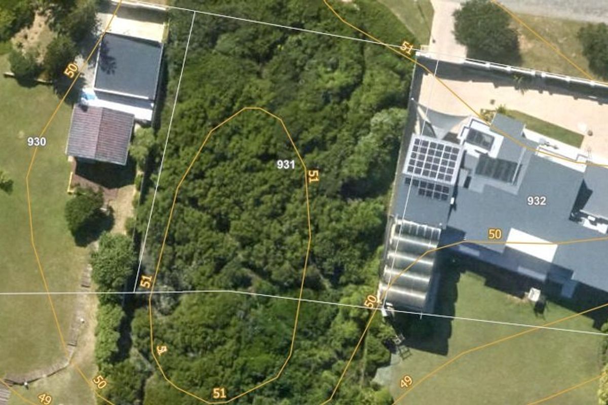 Aerial view of a vacant residential plot featuring dense natural vegetation and marked property boundaries.