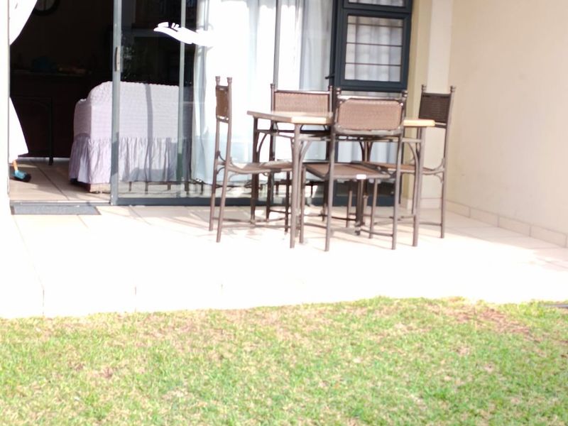 A covered patio area featuring tiled flooring and a large sliding glass door providing access to the interior living space.