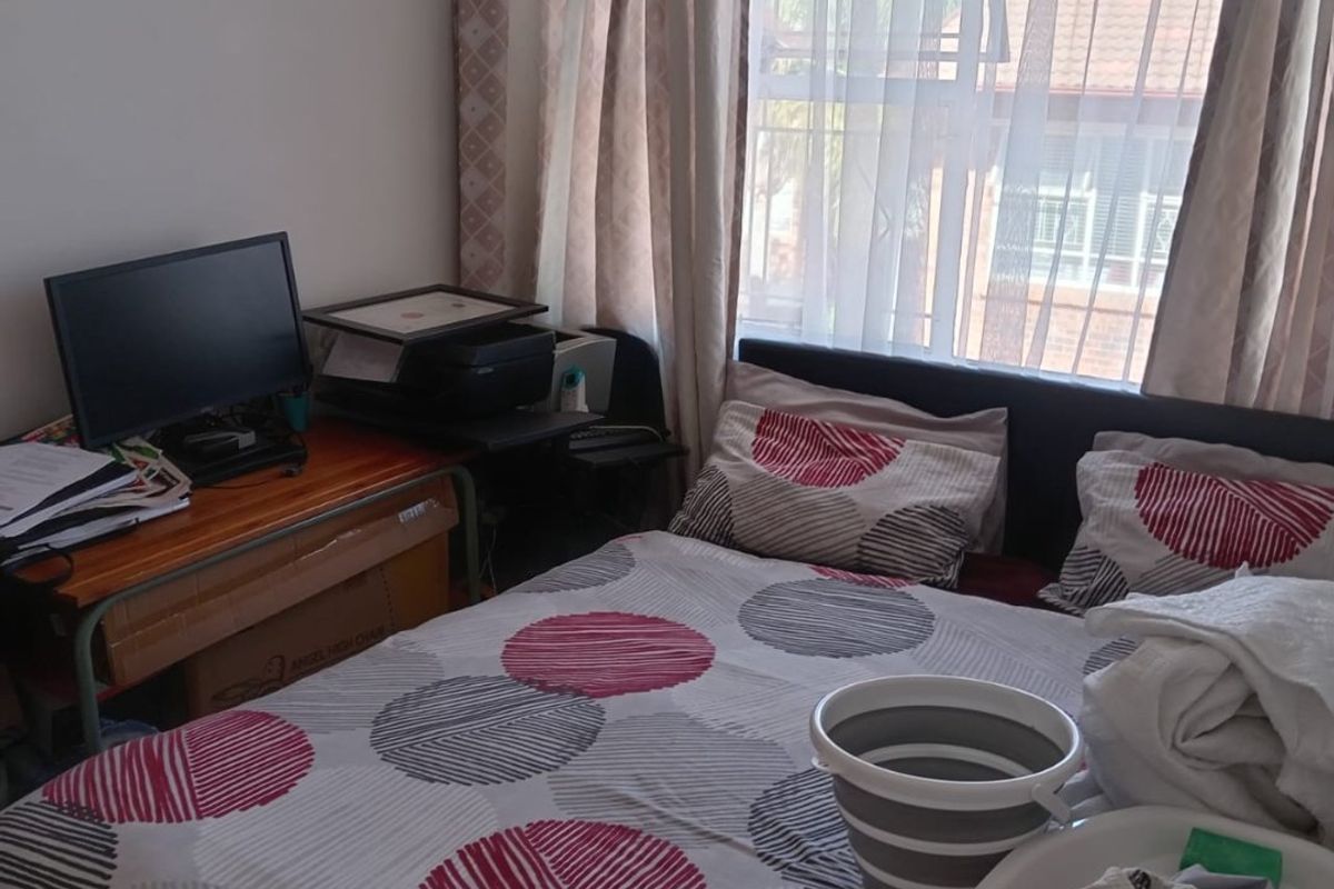 A bedroom featuring a window with curtains, providing natural light to the space.