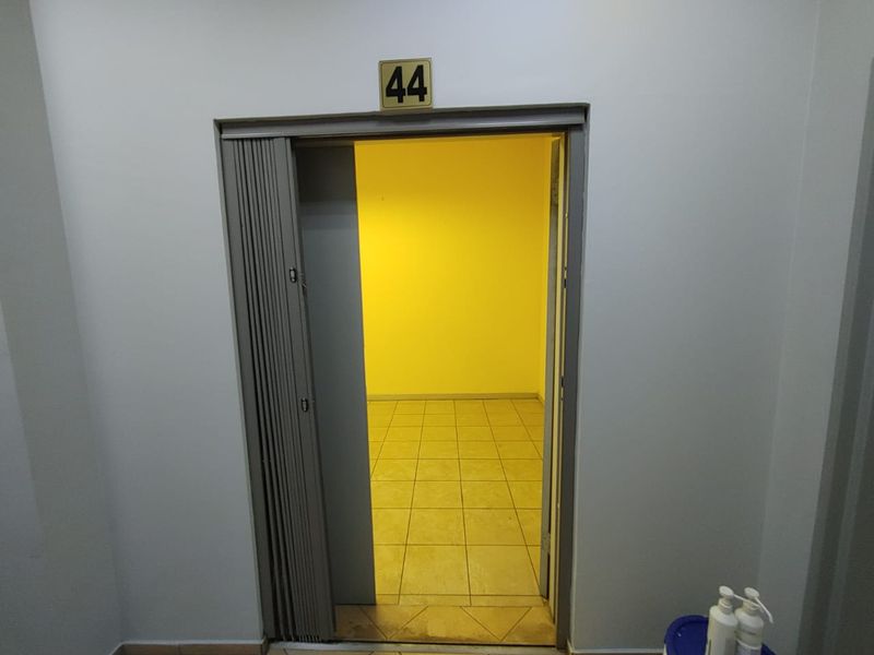 An empty utility space or storage room featuring ceramic floor tiles and a folding door entrance, marked as unit 44.