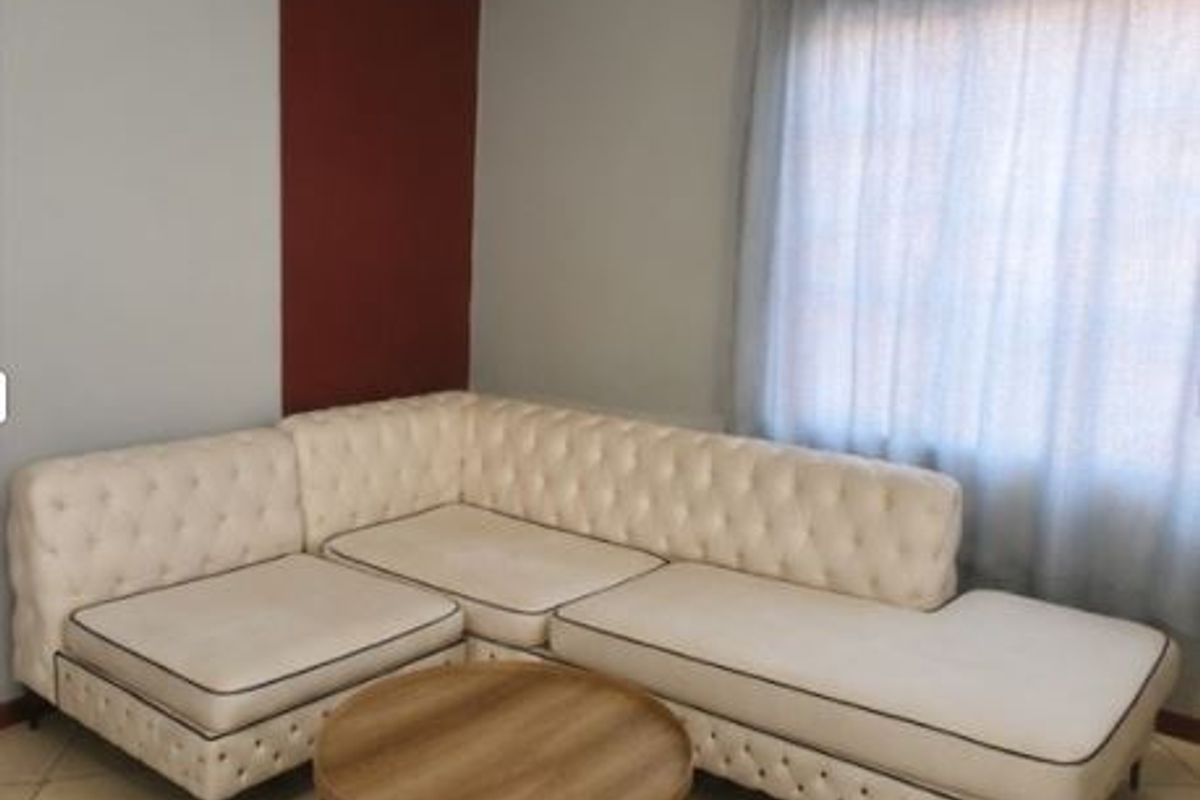 A living room area featuring tiled flooring and a window with a curtain rod, providing a neutral base for interior design.