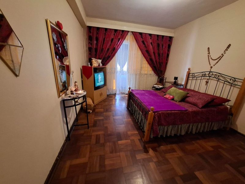 A bedroom featuring classic parquet flooring and a sliding glass door providing access to an outdoor area.