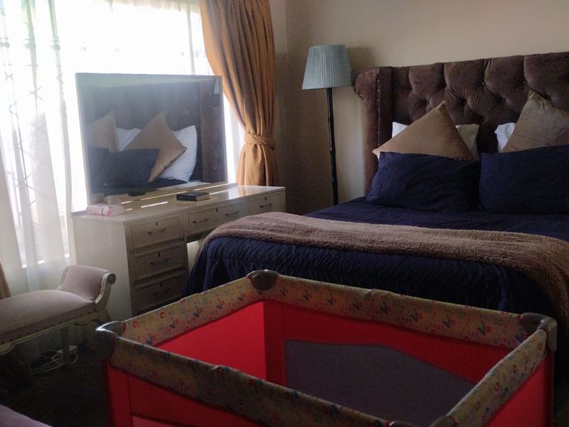 A bedroom featuring carpeted flooring and window treatments, providing a functional space for rest.