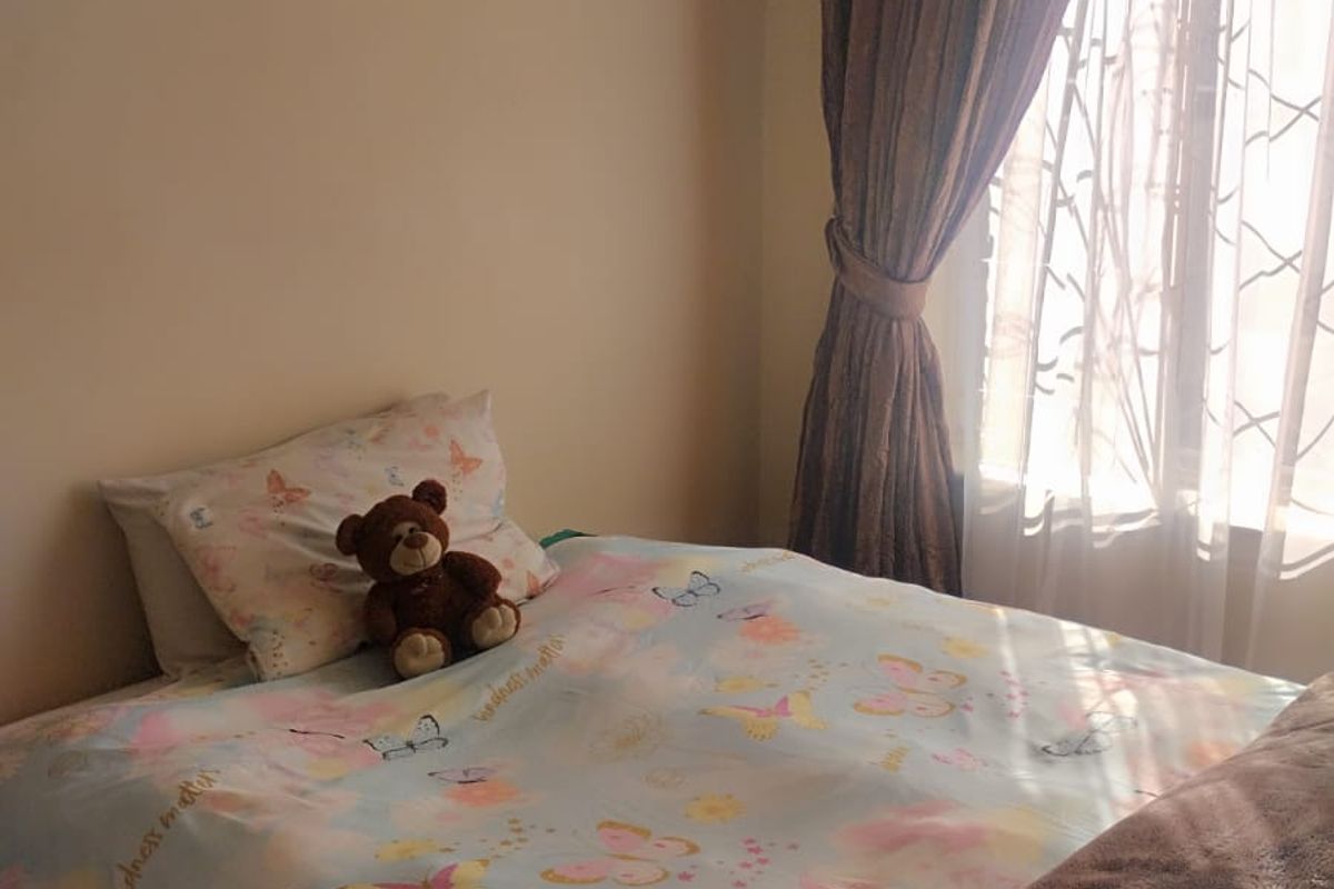 A bedroom featuring a window with installed curtain rails, providing natural light to the space.
