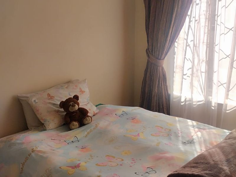 A bedroom featuring a window with installed curtain rails, providing natural light to the space.