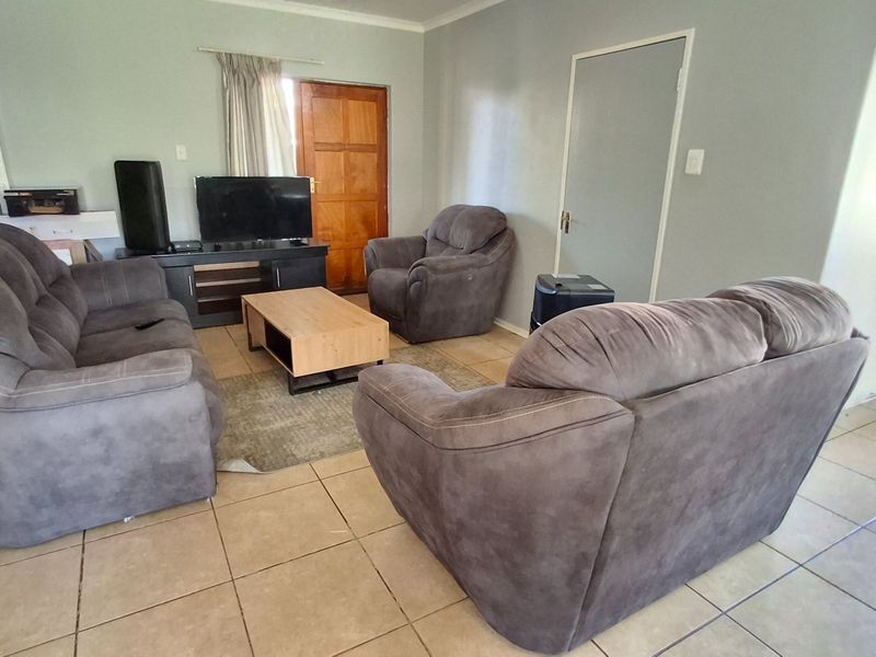 Open plan living area featuring tiled flooring and direct access to the kitchen and entrance.