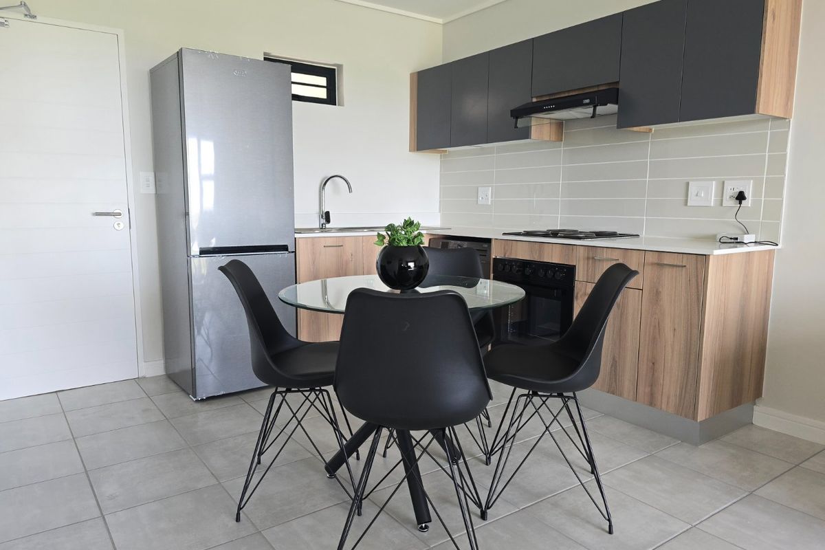 Modern kitchen featuring wood-grain and charcoal cabinetry, tiled backsplash, built-in oven, gas hob, and extractor fan, with integrated sink and tiled flooring.