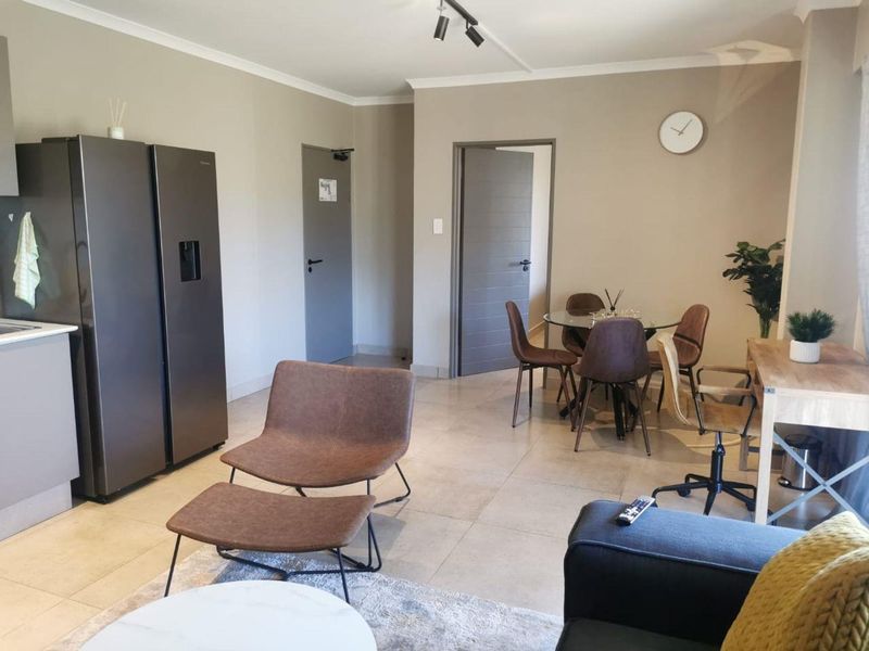 An open-plan living and dining area featuring neutral wall tones, tiled flooring, and modern internal doors, creating a functional and cohesive living space.