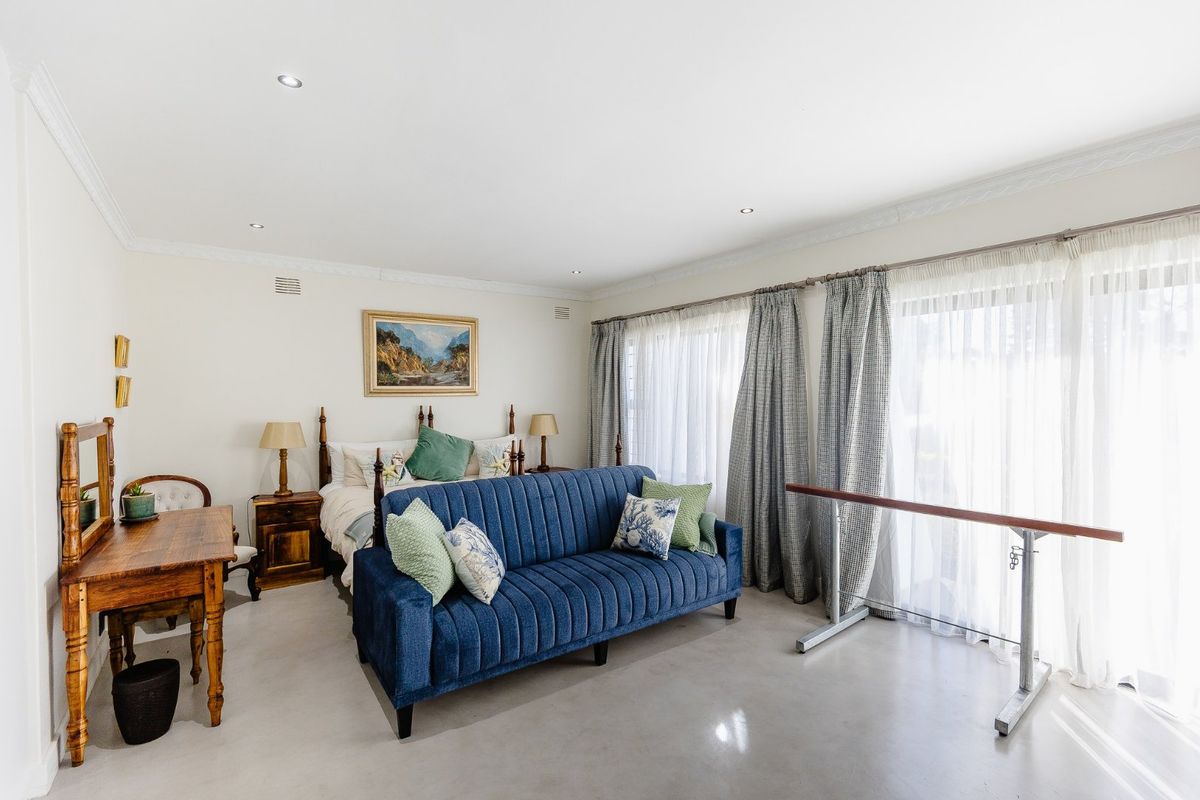 Spacious bedroom featuring polished concrete floors, recessed lighting, and large sliding glass doors providing ample natural light.