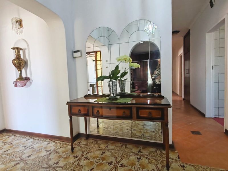 Entrance foyer featuring decorative tiled flooring, an arched wall niche, and a large mirrored feature wall, providing a classic and welcoming transition space.